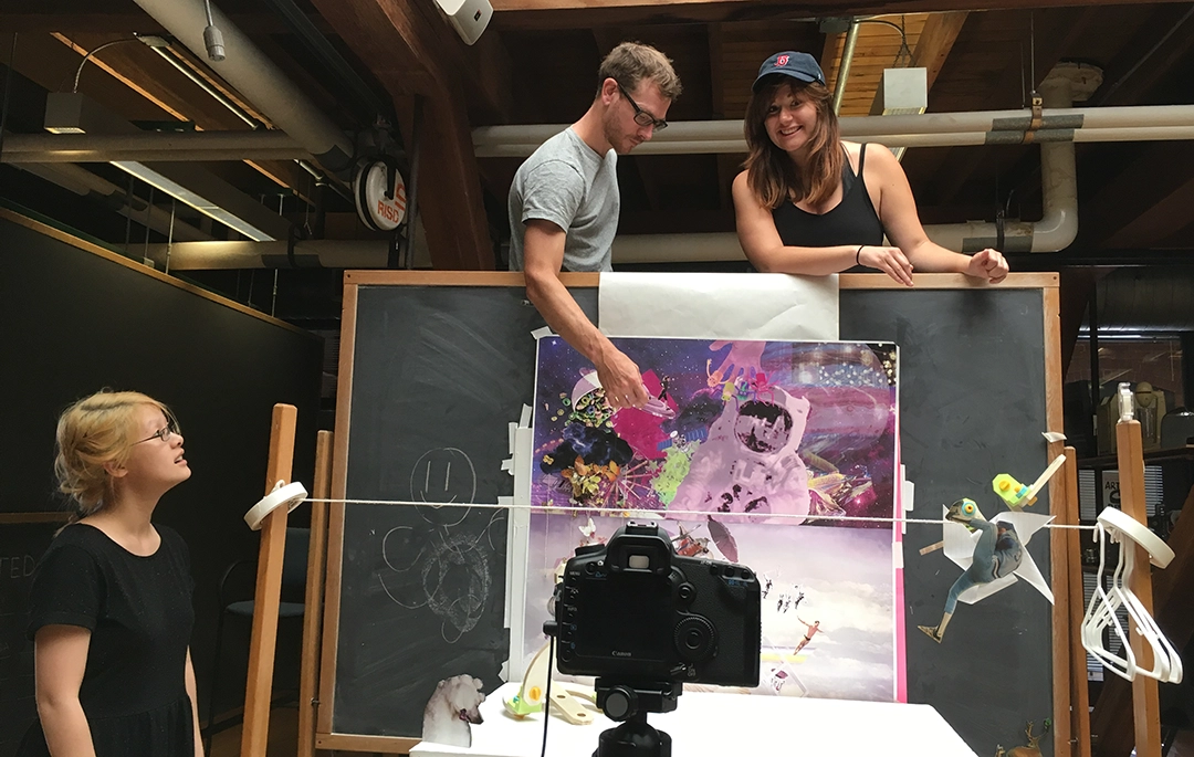 A photograph of three colleagues surrounded around a stop motion set